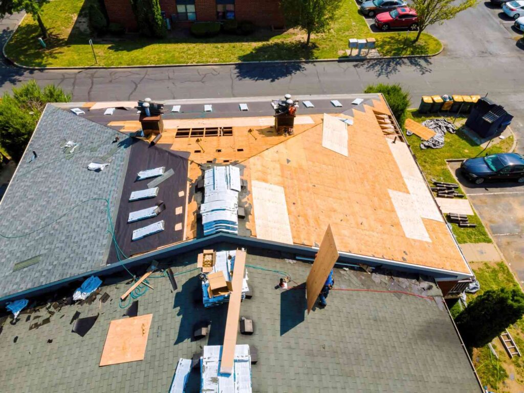 While repairing roof apartment building, old shingles replaced plywood and new shingles were installed.